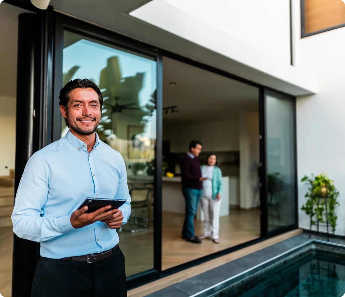 Man holding tablet by modern poolside
